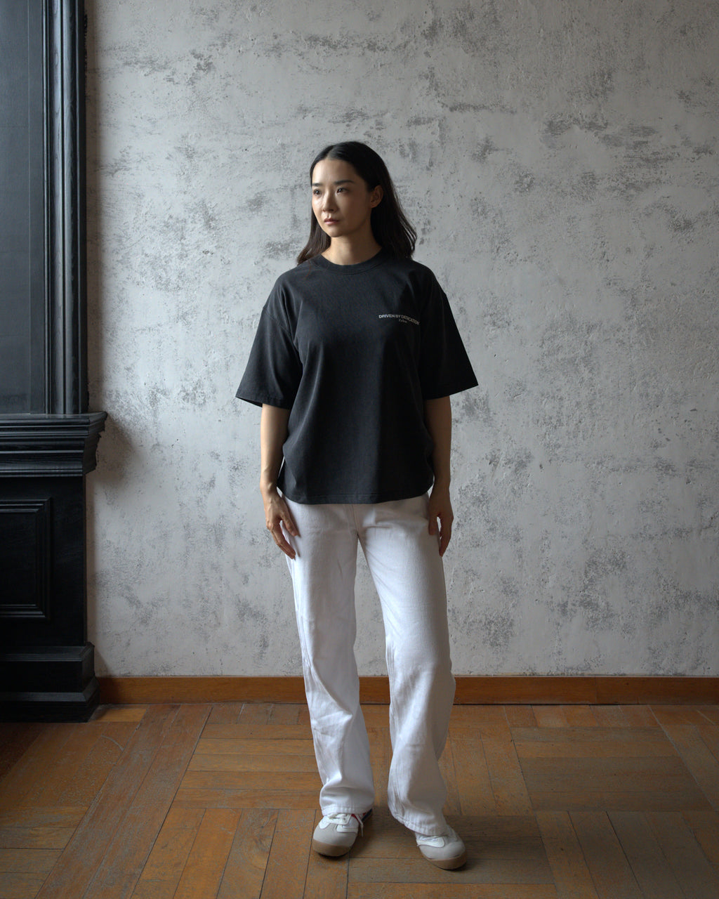 Female model wearing Zelos Tee Black in size S, front view